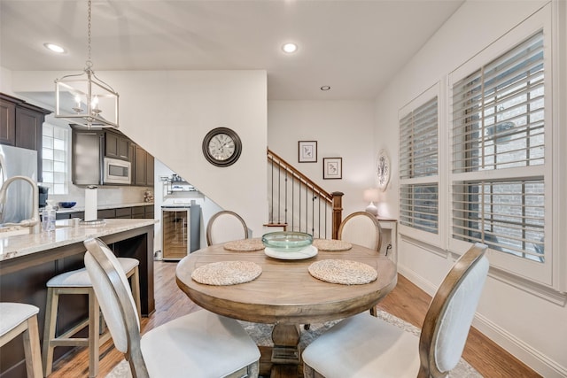 7320 San Saba Dr, Mckinney, TX 75070 - dining space with a chandelier, light wood-style flooring, stairway, recessed lighting, and wine cooler