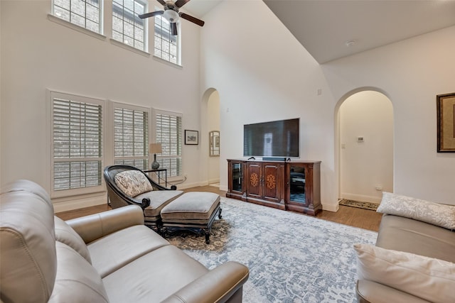 7320 San Saba Dr, Mckinney, TX 75070 - living area featuring arched walkways, a high ceiling, ceiling fan, and wood finished floors