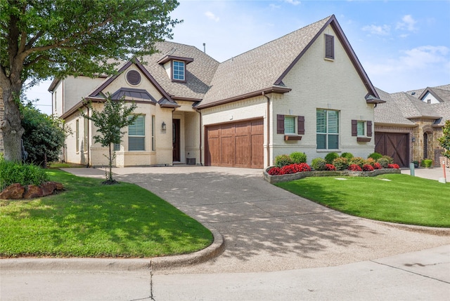 4804 Spicewood Ln, Arlington, TX 76017 - french country inspired facade with brick siding, a garage, roof with shingles, driveway, and a front yard