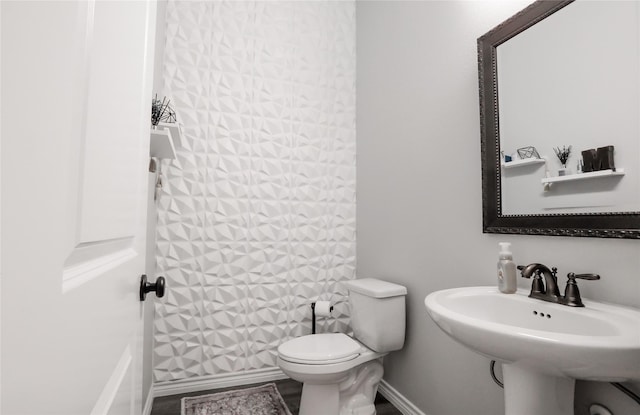 4804 Spicewood Ln, Arlington, TX 76017 - bathroom featuring toilet, baseboards, and a sink