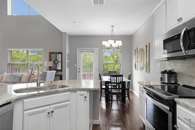 3421 Paisano Trl, Plano, TX 75093 - kitchen featuring appliances with stainless steel finishes, a sink, dark wood finished floors, a chandelier, and decorative backsplash