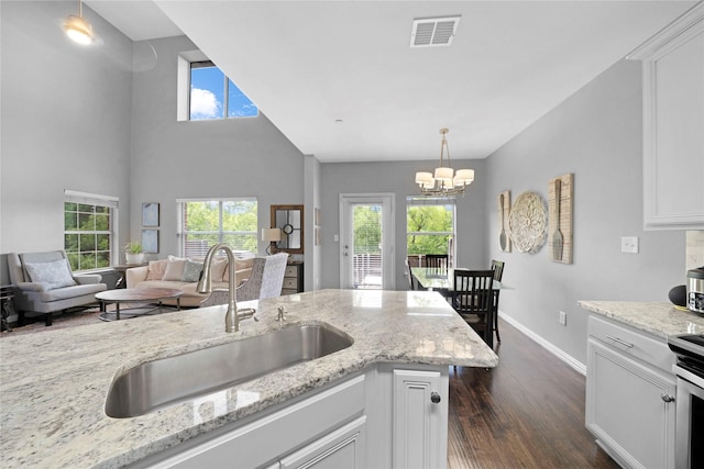 3421 Paisano Trl, Plano, TX 75093 - kitchen featuring a sink, dark wood-type flooring, baseboards, a chandelier, and plenty of natural light