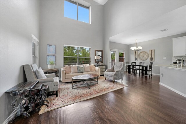 3421 Paisano Trl, Plano, TX 75093 - living room featuring a chandelier, dark wood finished floors, baseboards, and a towering ceiling