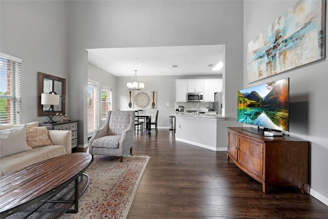3421 Paisano Trl, Plano, TX 75093 - living room featuring a chandelier, dark wood-style flooring, a high ceiling, and baseboards