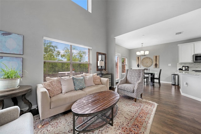 3421 Paisano Trl, Plano, TX 75093 - living area with a chandelier, dark wood-style flooring, a high ceiling, and baseboards