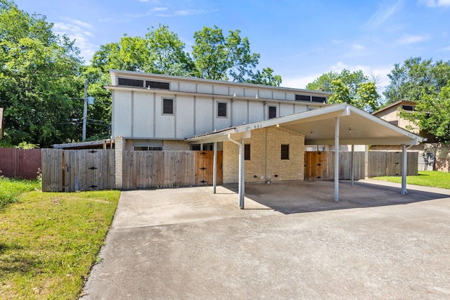 531 Norwood Cir E, Arlington, TX 76013 - view of front of property featuring driveway, board and batten siding, brick siding, a gate, and an attached carport
