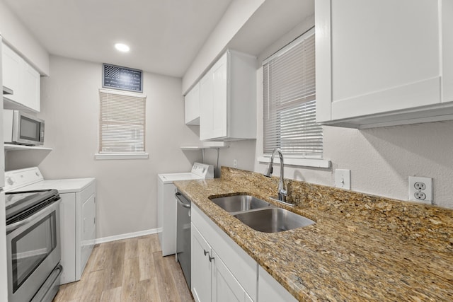 531 Norwood Cir E, Arlington, TX 76013 - kitchen with independent washer and dryer, a sink, light wood-style flooring, white cabinetry, and appliances with stainless steel finishes