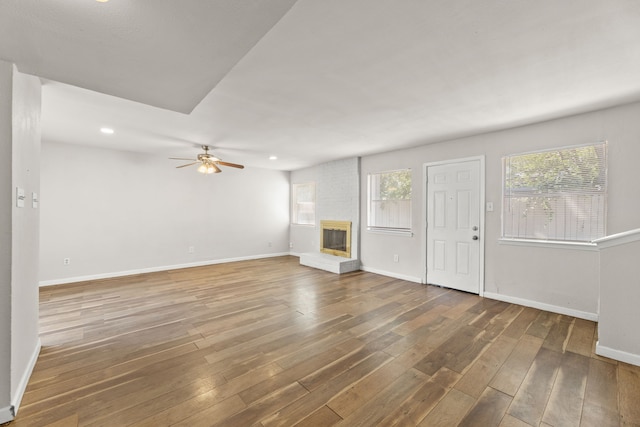 531 Norwood Cir E, Arlington, TX 76013 - unfurnished living room featuring hardwood / wood-style floors, a brick fireplace, ceiling fan, baseboards, and recessed lighting