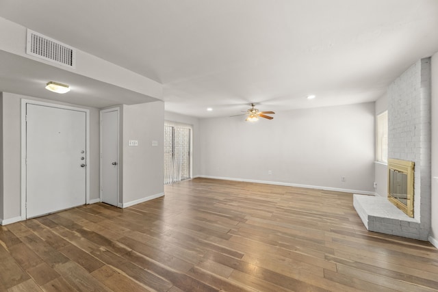 531 Norwood Cir E, Arlington, TX 76013 - unfurnished living room with hardwood / wood-style flooring, a brick fireplace, ceiling fan, baseboards, and recessed lighting