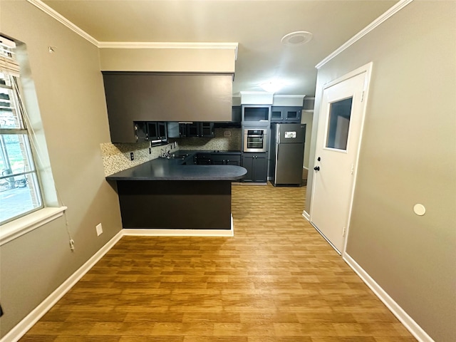 202 Wanda Dr, Winnsboro, TX 75494 - kitchen with freestanding refrigerator, oven, a peninsula, crown molding, and decorative backsplash