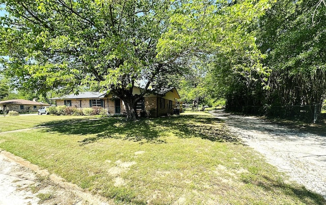 202 Wanda Dr, Winnsboro, TX 75494 - view of front of property with a front yard, dirt driveway, and brick siding