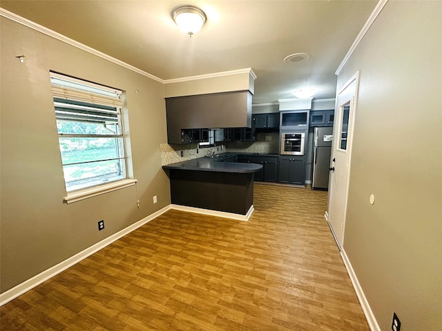 202 Wanda Dr, Winnsboro, TX 75494 - kitchen featuring oven, a peninsula, dark countertops, backsplash, and ornamental molding