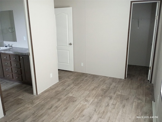 124 Eldorado St, Decatur, TX 76234 - unfurnished bedroom with a spacious closet, wood finished floors, a sink, a closet, and connected bathroom