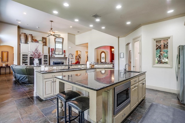 6700 Lions Gate Ct, Arlington, TX 76001 - kitchen featuring a sink, appliances with stainless steel finishes, ornamental molding, a kitchen island with sink, and stone tile flooring