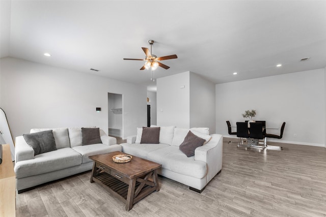 living room featuring light wood-style floors, ceiling fan, recessed lighting, and baseboards