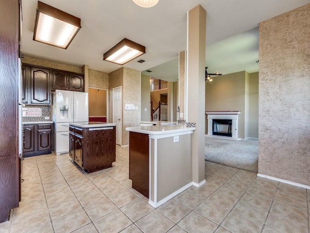 2540 Briardale Dr, Carrollton, TX 75006 - kitchen with white fridge with ice dispenser, light tile patterned floors, light countertops, a kitchen island, and dark brown cabinets