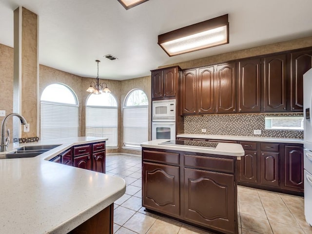 2540 Briardale Dr, Carrollton, TX 75006 - kitchen featuring white appliances, a sink, light tile patterned floors, a center island, and light countertops