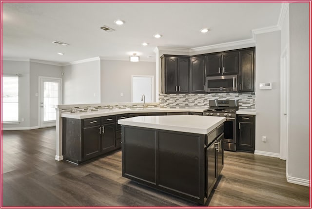 5005 Odeum Ct, Fort Worth, TX 76244 - kitchen featuring appliances with stainless steel finishes, a sink, decorative backsplash, a center island, and light countertops