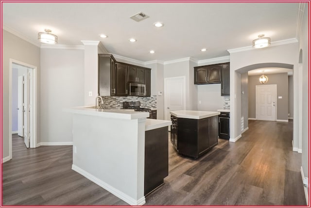 5005 Odeum Ct, Fort Worth, TX 76244 - kitchen with appliances with stainless steel finishes, arched walkways, tasteful backsplash, dark wood finished floors, and recessed lighting