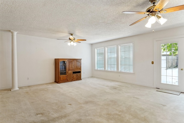 1508 Raborn Dr, Bowie, TX 76230 - unfurnished living room featuring a ceiling fan, light colored carpet, ornate columns, a textured ceiling, and baseboards