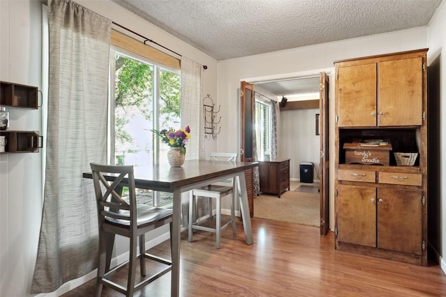 1512 Hulme St, Bowie, TX 76230 - dining room with light wood finished floors, a textured ceiling, and ornamental molding
