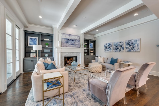 living area featuring healthy amount of natural light, dark wood-type flooring, beam ceiling, crown molding, and a high end fireplace