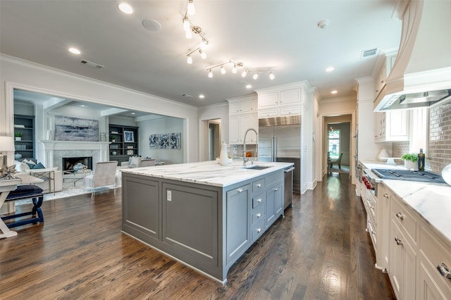 kitchen featuring gray cabinets, a sink, light stone countertops, ornamental molding, and backsplash