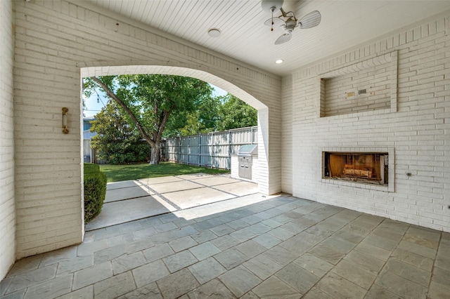 unfurnished living room featuring stone tile flooring, ceiling fan, an outdoor brick fireplace, and recessed lighting