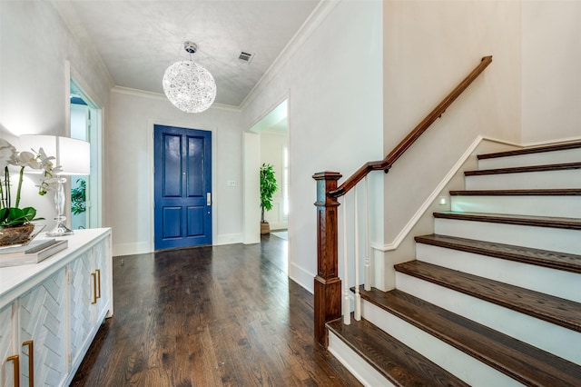 entryway with stairs, dark wood finished floors, a chandelier, ornamental molding, and baseboards