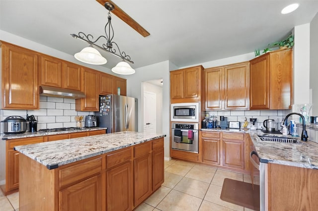 4624 Southpointe Dr, Richardson, TX 75082 - kitchen featuring appliances with stainless steel finishes, under cabinet range hood, a sink, and light stone counters