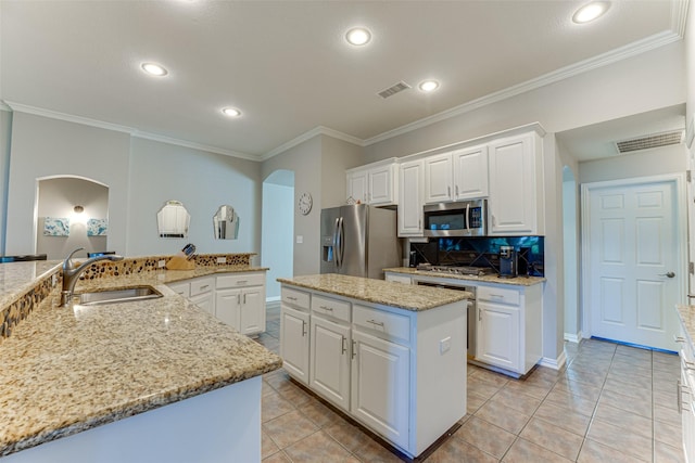2505 Hillary Trl, Mansfield, TX 76063 - kitchen featuring stainless steel appliances, a center island, arched walkways, a sink, and ornamental molding