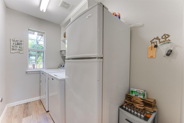 2505 Hillary Trl, Mansfield, TX 76063 - laundry room with light wood finished floors, washer and clothes dryer, and baseboards