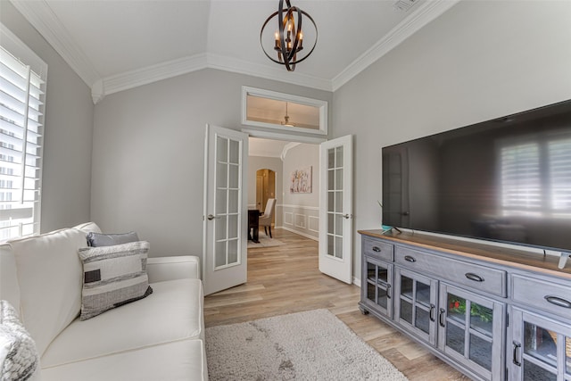 2505 Hillary Trl, Mansfield, TX 76063 - living room with french doors, crown molding, arched walkways, light wood-style floors, and a chandelier