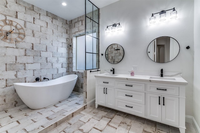 full bath featuring a freestanding tub, double vanity, and baseboards