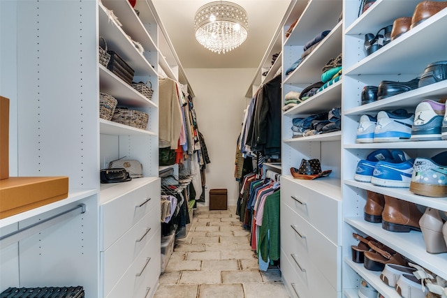 walk in closet featuring a chandelier