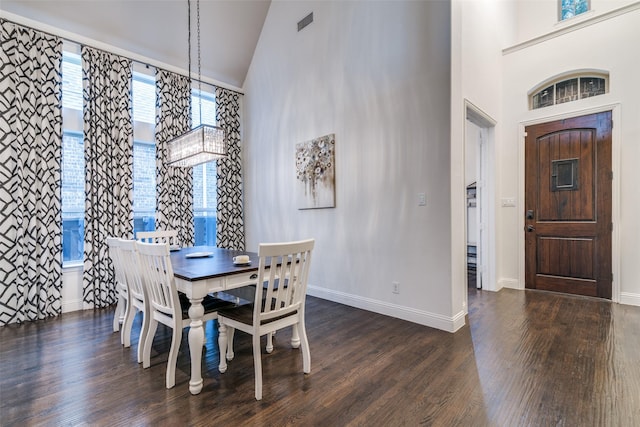 dining space with high vaulted ceiling, dark wood finished floors, and baseboards