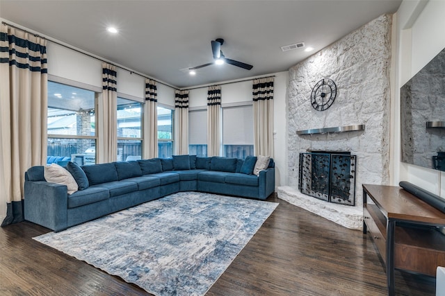 living room featuring a fireplace, ceiling fan, and dark wood-style flooring
