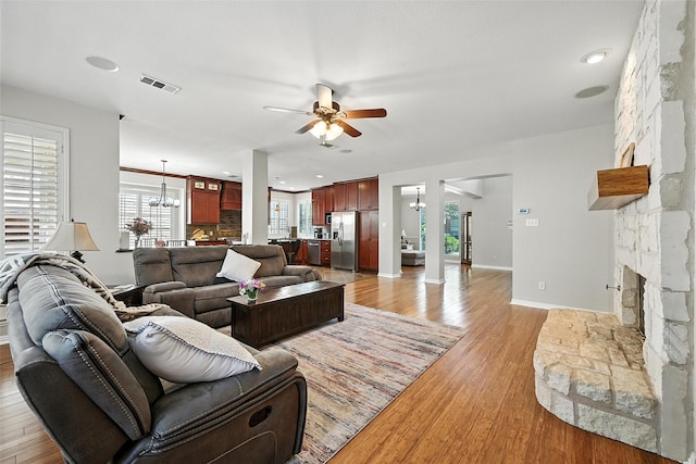 2726 Bandolier Ln, Frisco, TX 75033 - living room with a ceiling fan, a chandelier, a fireplace, light wood finished floors, and recessed lighting