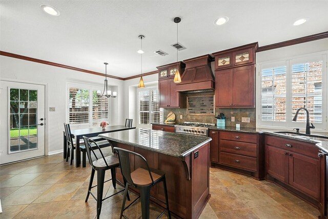 2726 Bandolier Ln, Frisco, TX 75033 - kitchen with premium range hood, a kitchen island, backsplash, glass insert cabinets, and a chandelier
