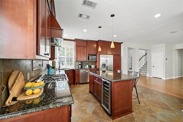 2726 Bandolier Ln, Frisco, TX 75033 - kitchen with appliances with stainless steel finishes, wine cooler, a kitchen bar, backsplash, and dark stone countertops