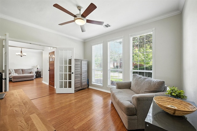 2726 Bandolier Ln, Frisco, TX 75033 - living area with wood finished floors, crown molding, a chandelier, ceiling fan, and french doors