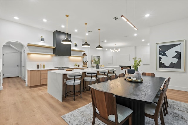 426 Avenue Ave E, Dallas, TX 75203 - dining room featuring light wood finished floors, arched walkways, recessed lighting, and a chandelier