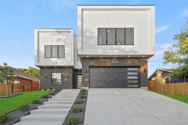 426 Avenue Ave E, Dallas, TX 75203 - contemporary house with brick siding, a garage, concrete driveway, and board and batten siding
