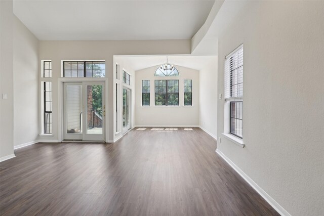 unfurnished living room featuring a chandelier, dark wood-style floors, and baseboards