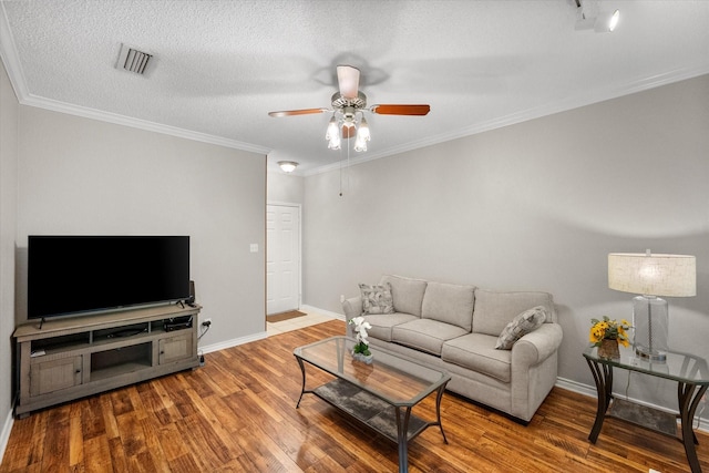 2101 Saint Michaels Dr Unit 109, Arlington, TX 76011 - living room featuring a ceiling fan, wood finished floors, baseboards, ornamental molding, and a textured ceiling