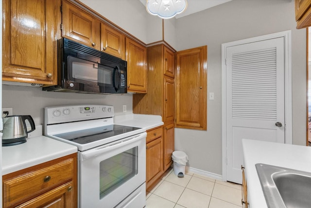 2101 Saint Michaels Dr Unit 109, Arlington, TX 76011 - kitchen featuring white electric stove, black microwave, a sink, and brown cabinetry