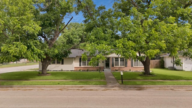 610 Phillips St, Cleburne, TX 76033 - view of front of home with brick siding, a front yard, and central AC unit