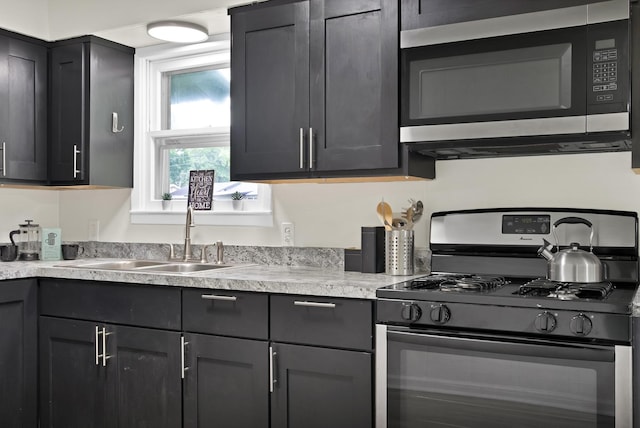 610 Phillips St, Cleburne, TX 76033 - kitchen with stainless steel microwave, gas stove, a sink, and light countertops