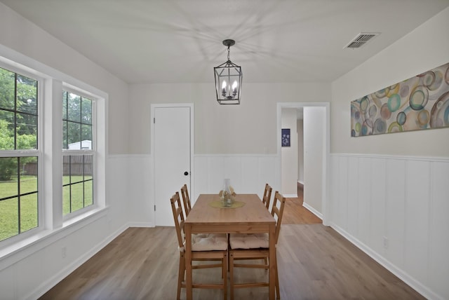 610 Phillips St, Cleburne, TX 76033 - dining space featuring wood finished floors, a wainscoted wall, and a chandelier