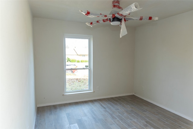 spare room featuring wood finished floors and baseboards